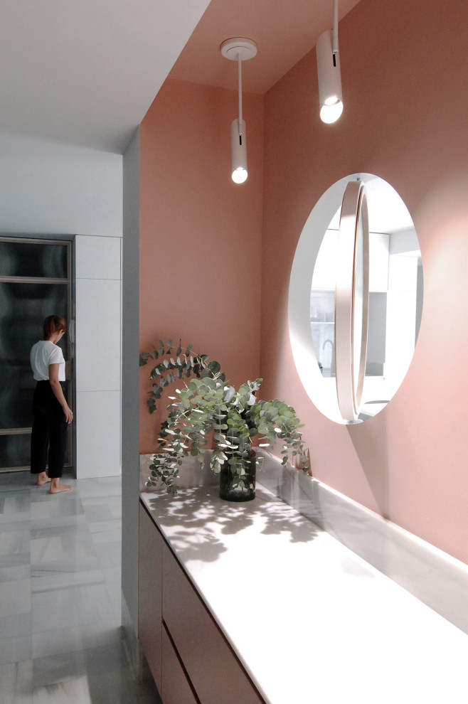 Идея дизайна: вестибюль среднего размера в стиле модернизм с розовыми стенами, мраморным полом, поворотной входной дверью, входной дверью из светлого дерева и серым полом