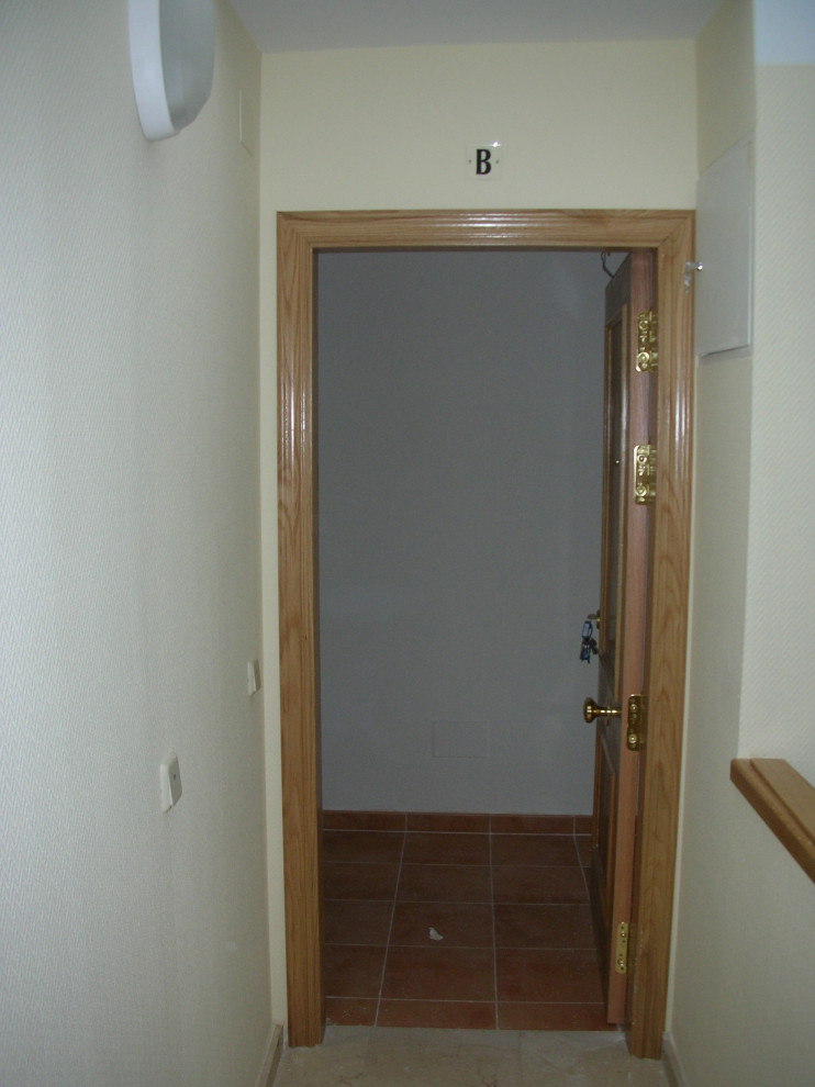 Modelo de puerta principal minimalista pequeña con paredes amarillas, suelo de mármol, puerta simple, puerta de madera en tonos medios y suelo beige