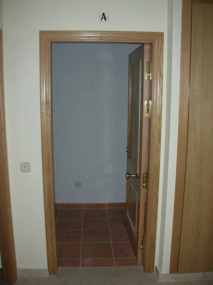 Esempio di una piccola porta d'ingresso minimalista con pareti gialle, pavimento in marmo, una porta singola, una porta in legno bruno e pavimento beige