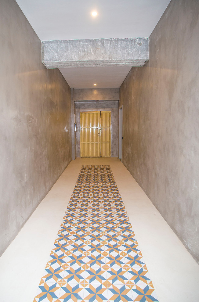 Industrial Haustür mit grauer Wandfarbe, Betonboden und buntem Boden in Barcelona