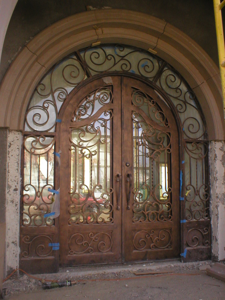 This is an example of a mediterranean front door in Santa Barbara with beige walls, a double front door and a glass front door.