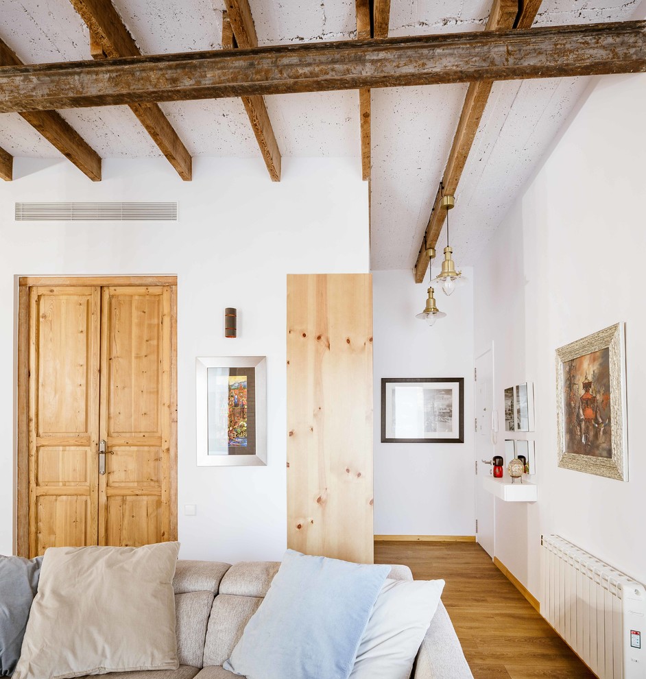 Diseño de hall industrial pequeño con paredes blancas, suelo de madera en tonos medios, puerta simple y puerta blanca