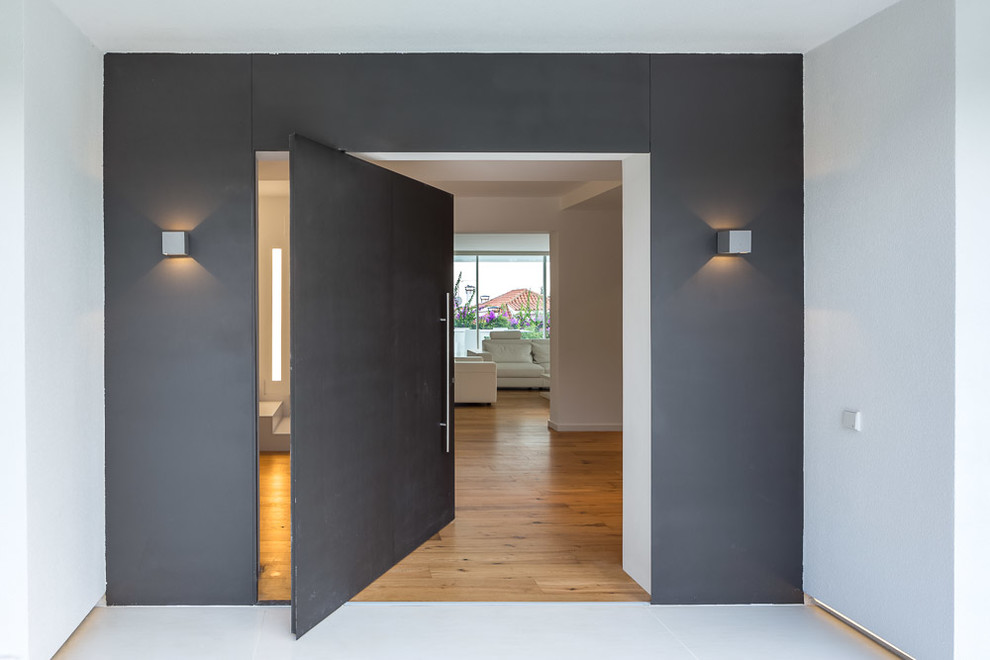 Inspiration pour une porte d'entrée design de taille moyenne avec une porte pivot, une porte grise et un mur gris.