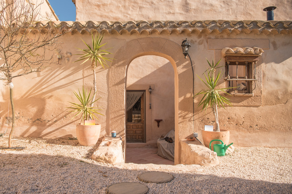 Diseño de puerta principal mediterránea con paredes beige, puerta simple y puerta de madera en tonos medios