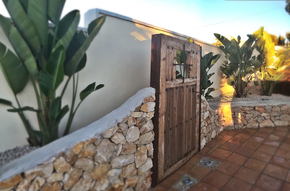 Modelo de puerta principal mediterránea de tamaño medio con paredes beige y puerta de madera oscura