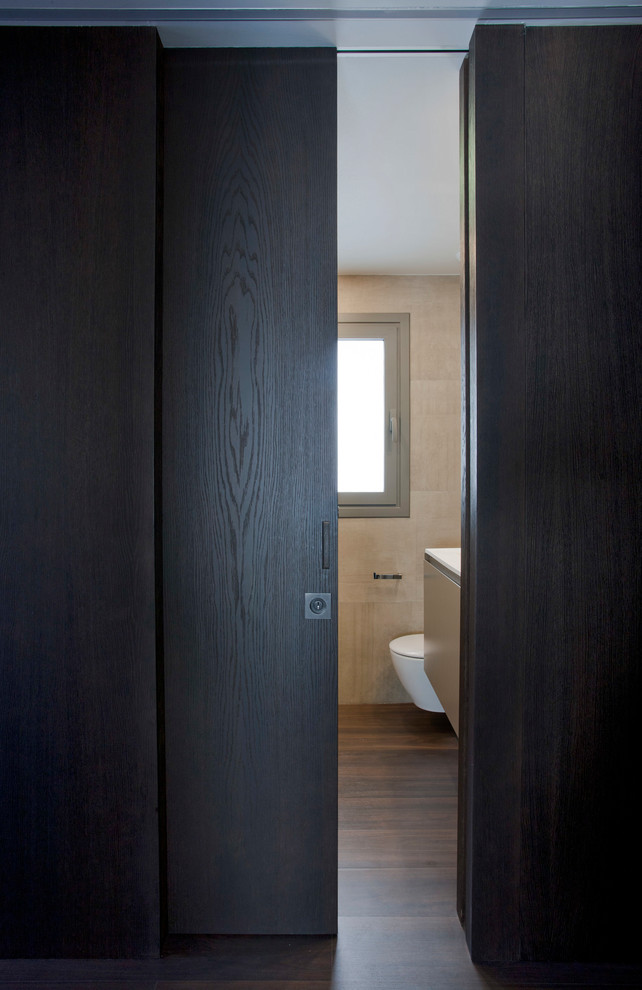Foto de distribuidor minimalista de tamaño medio con paredes marrones, suelo de madera oscura, puerta corredera y puerta de madera oscura
