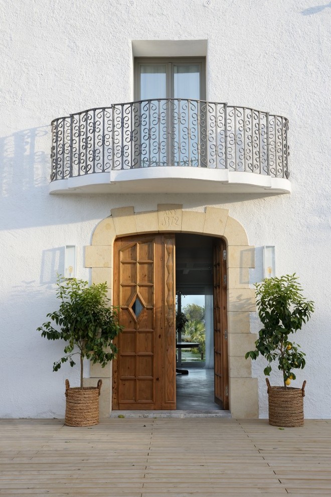 Пример оригинального дизайна: входная дверь среднего размера в средиземноморском стиле с белыми стенами, паркетным полом среднего тона, двустворчатой входной дверью и входной дверью из дерева среднего тона