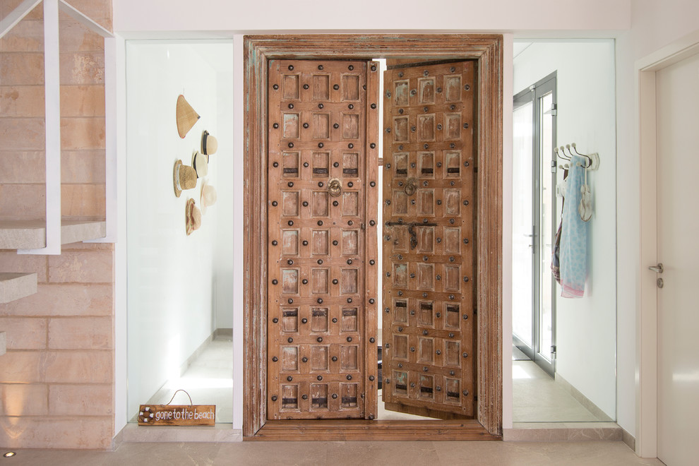 Design ideas for a mediterranean front door in Palma de Mallorca with white walls, a double front door and a medium wood front door.