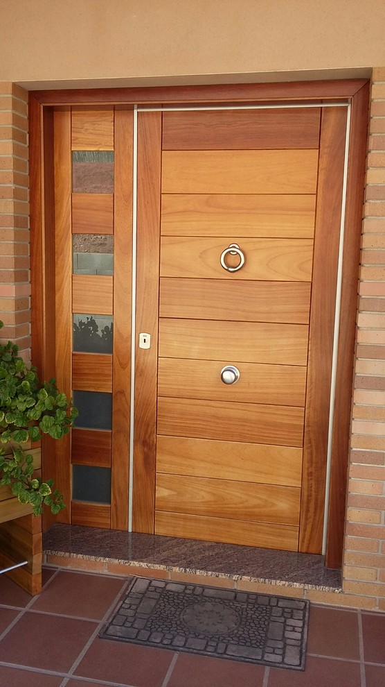 Ejemplo de entrada de estilo de casa de campo pequeña con puerta de madera en tonos medios