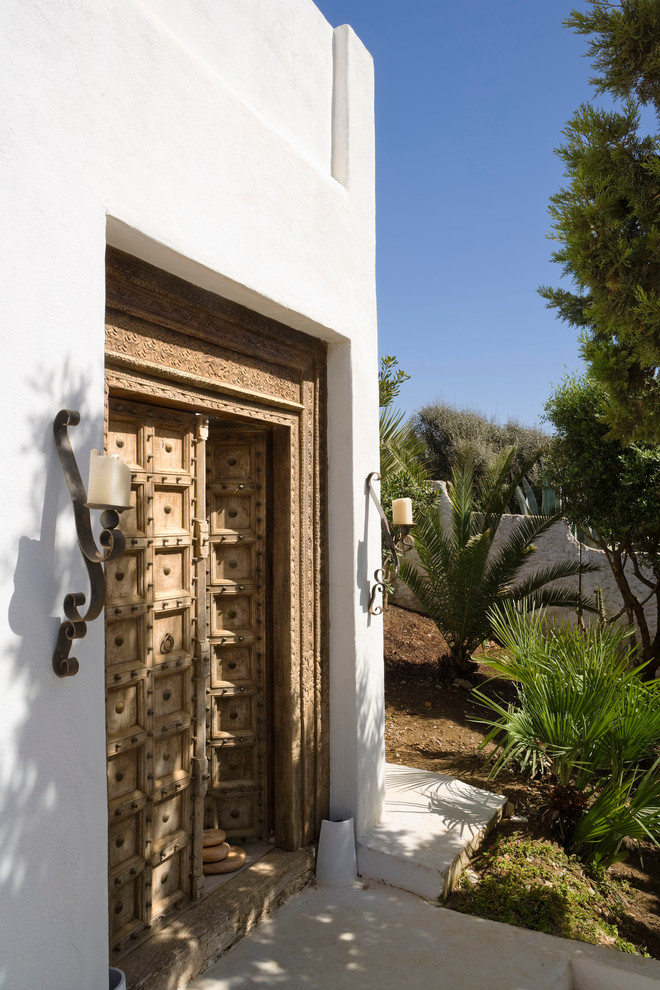Ispirazione per una porta d'ingresso mediterranea di medie dimensioni con pareti bianche, una porta a due ante e una porta in legno bruno