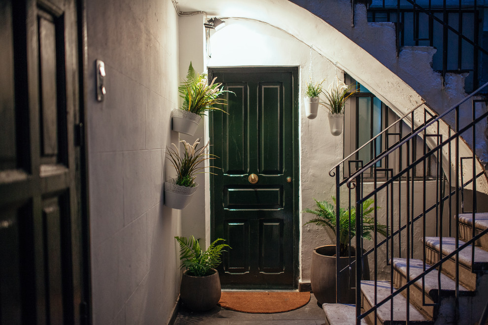 Kleine Urige Haustür mit grauer Wandfarbe, Einzeltür und grüner Haustür in Madrid