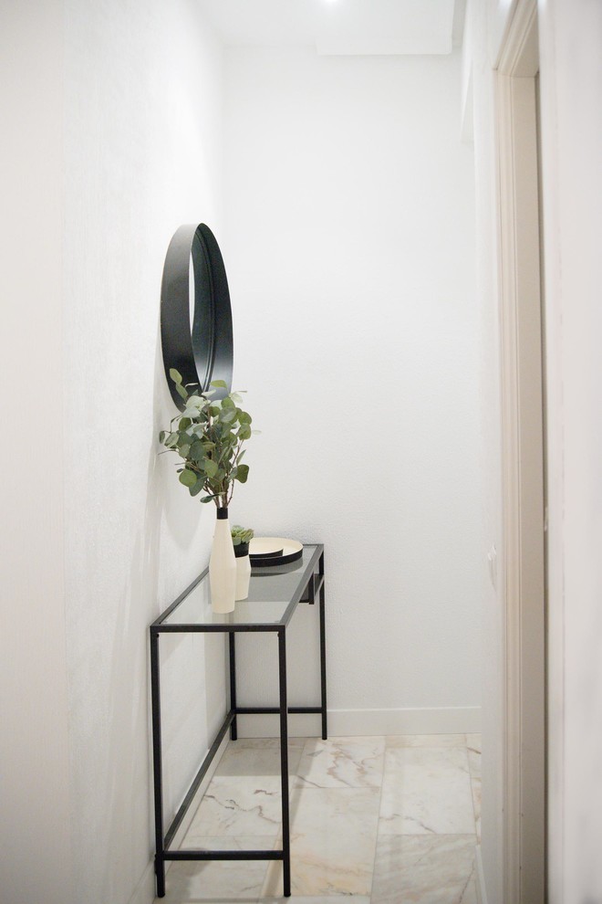 На фото: маленькая узкая прихожая в стиле лофт с белыми стенами, мраморным полом, одностворчатой входной дверью, белой входной дверью и белым полом для на участке и в саду