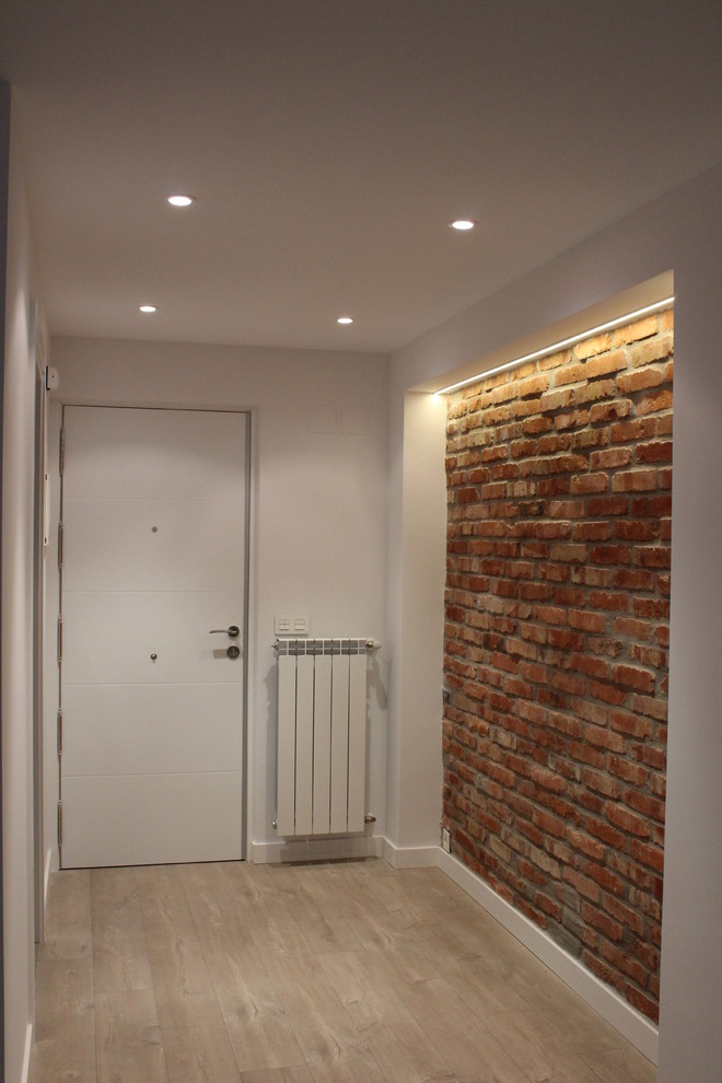 Foto de hall urbano pequeño con suelo de madera clara, puerta simple y puerta blanca