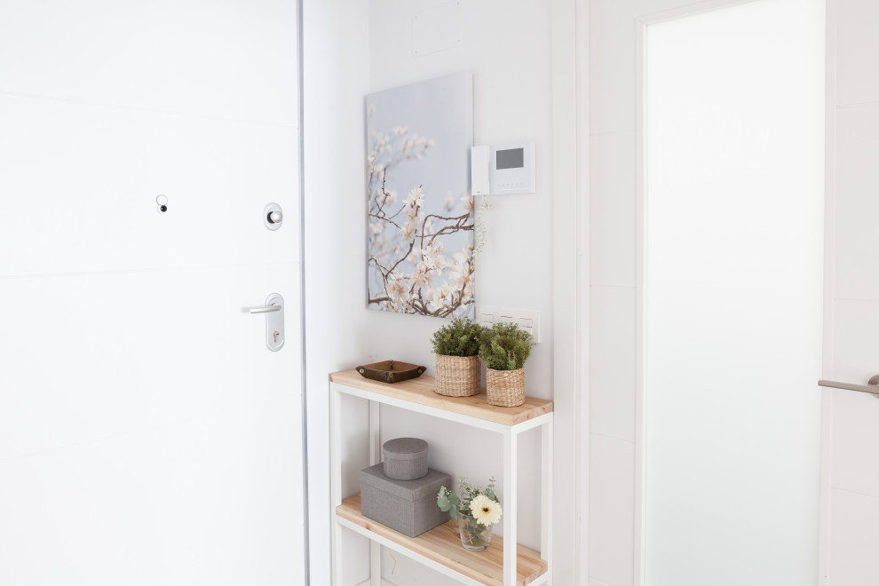 This is an example of a small scandinavian hallway in Madrid with white walls, ceramic flooring, a single front door, a white front door and brown floors.