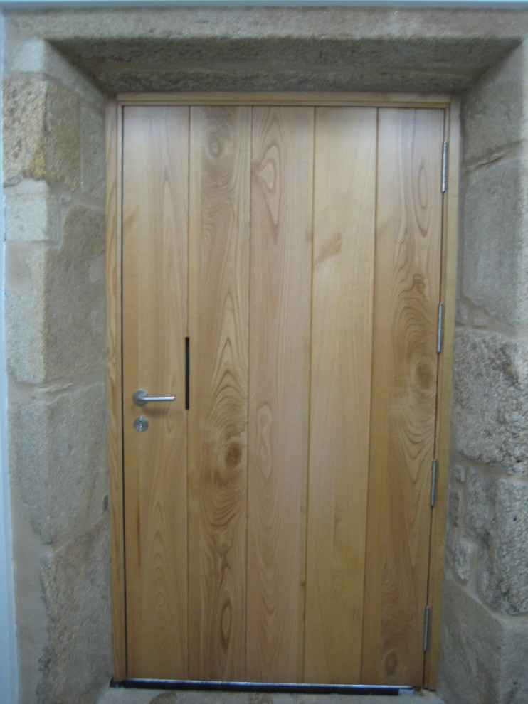 Ejemplo de puerta principal nórdica con paredes blancas, suelo de madera clara, puerta pivotante y puerta de madera clara
