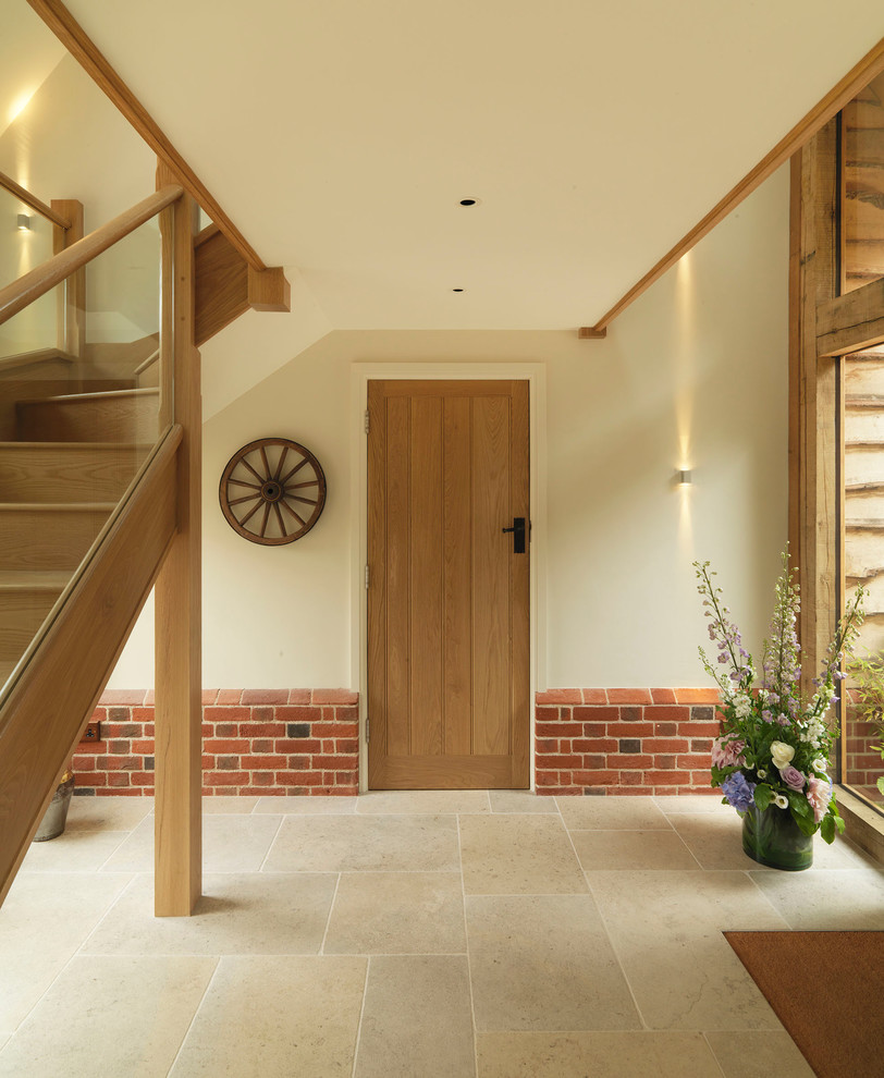 Design ideas for a large country vestibule in Hampshire with beige walls, limestone flooring, a stable front door and a light wood front door.