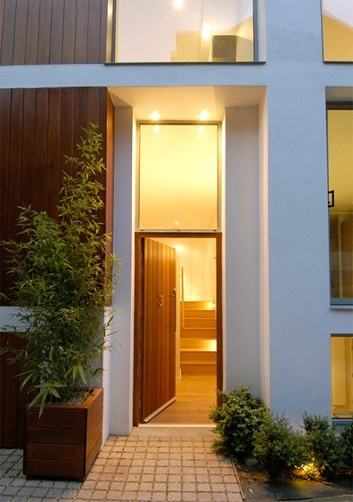 Idéer för en modern ingång och ytterdörr, med vita väggar, ljust trägolv, en enkeldörr och mellanmörk trädörr