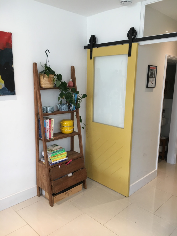 Aménagement d'une entrée contemporaine de taille moyenne avec un couloir, un mur blanc, un sol en carrelage de céramique, une porte coulissante, une porte jaune et un sol gris.