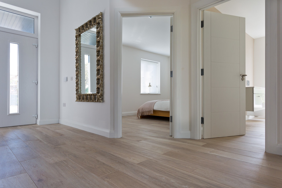 Modelo de hall escandinavo grande con paredes blancas, suelo de baldosas de porcelana, puerta simple y puerta blanca