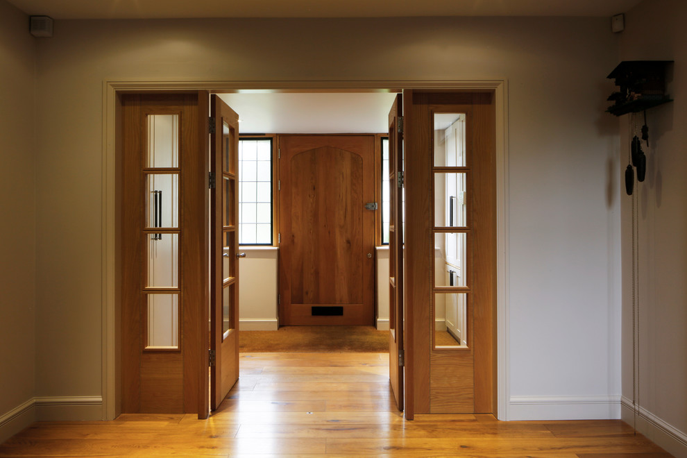 Photo of a large traditional front door in London with grey walls, medium hardwood flooring, a single front door, a medium wood front door and brown floors.