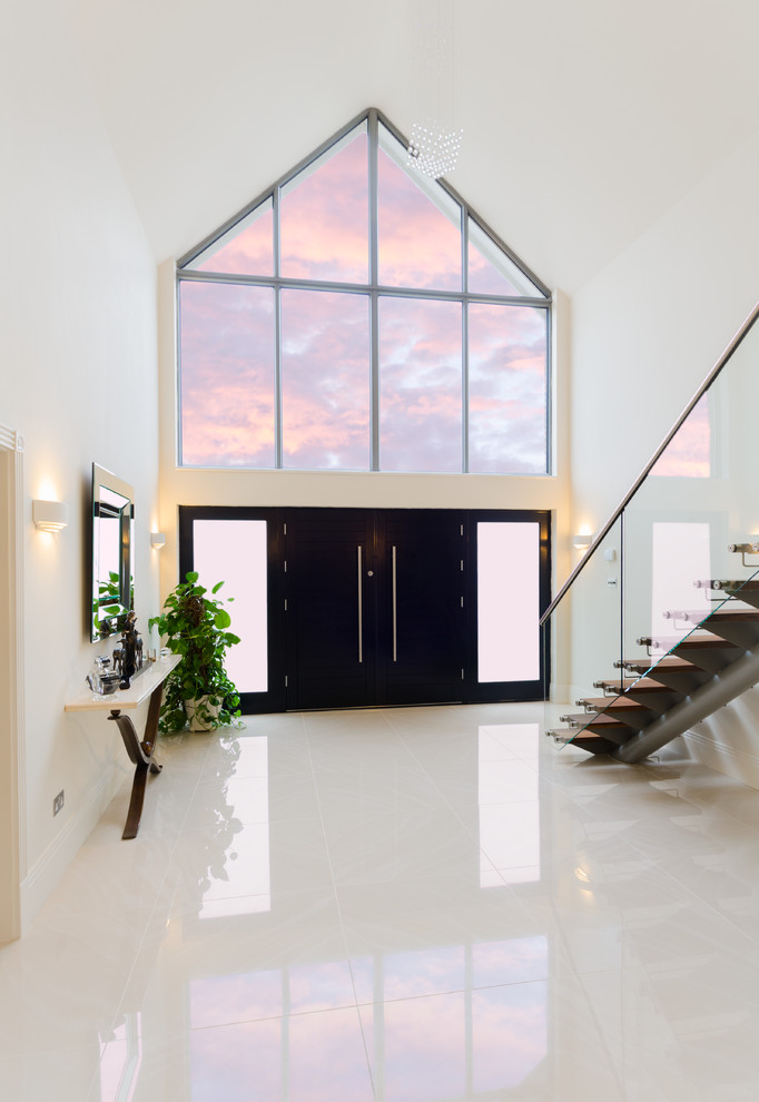 Inspiration for an expansive contemporary foyer in London with white walls, ceramic flooring, a double front door and a black front door.