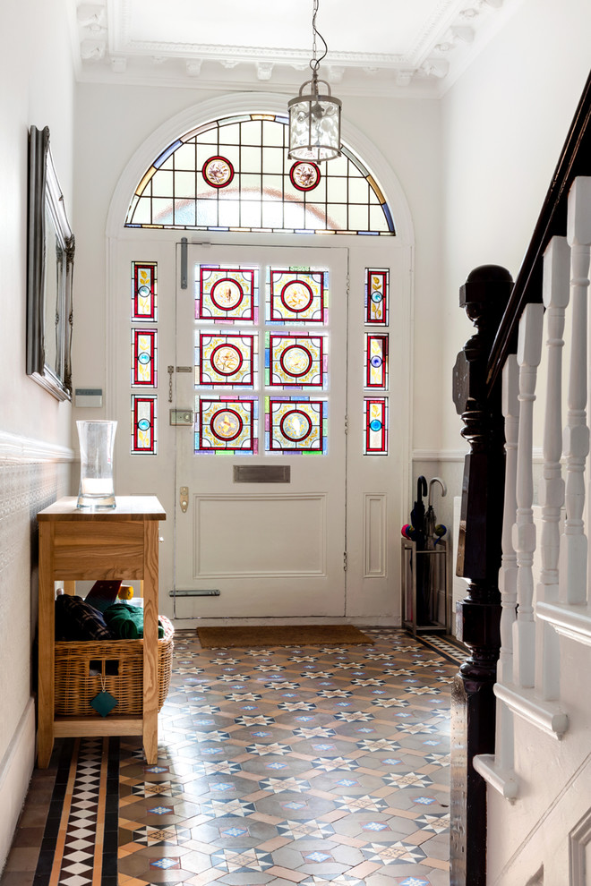 ロンドンにあるトラディショナルスタイルのおしゃれな玄関 (白い壁、ガラスドア) の写真