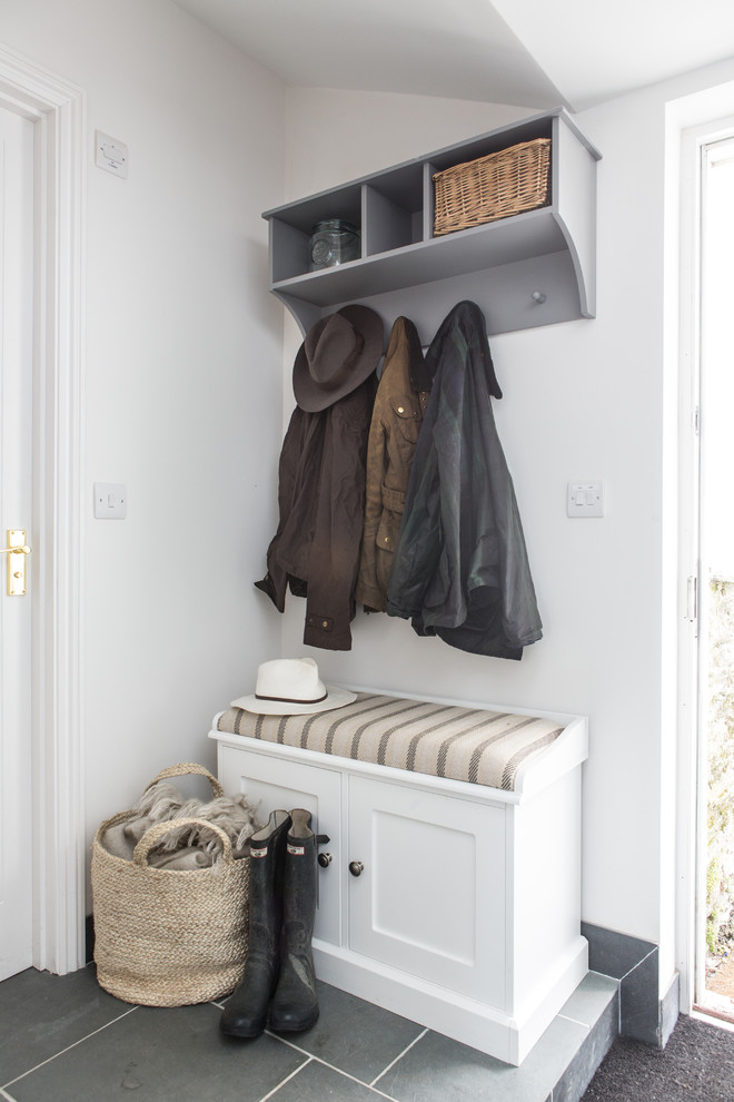 Example of a small beach style mudroom design in Cornwall with white walls