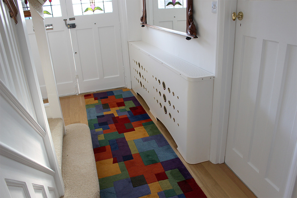 Large contemporary hallway in Other with white walls, light hardwood flooring, a single front door and a white front door.