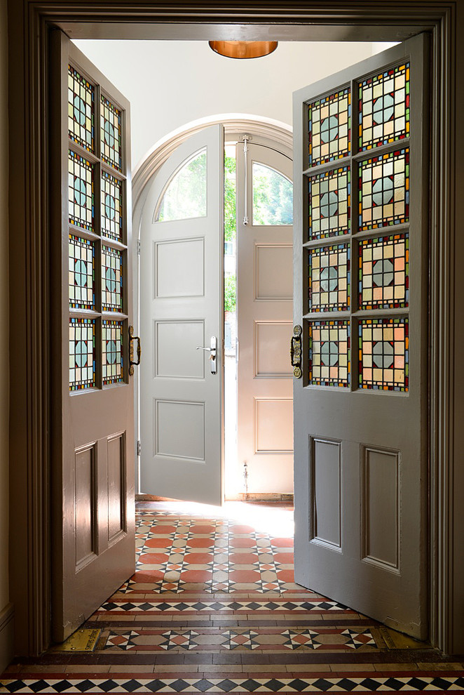 サリーにある中くらいなヴィクトリアン調のおしゃれな玄関ラウンジ (白い壁、テラコッタタイルの床、白いドア) の写真