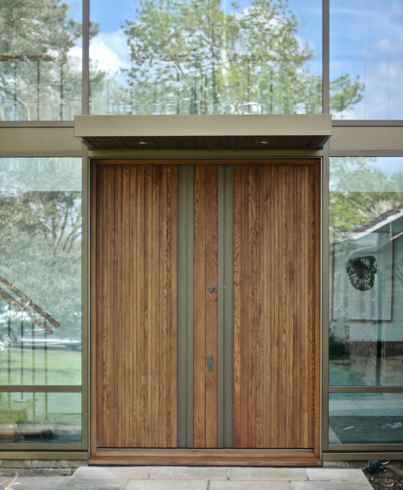 Immagine di una grande porta d'ingresso minimal con pareti bianche, una porta singola e una porta in legno scuro