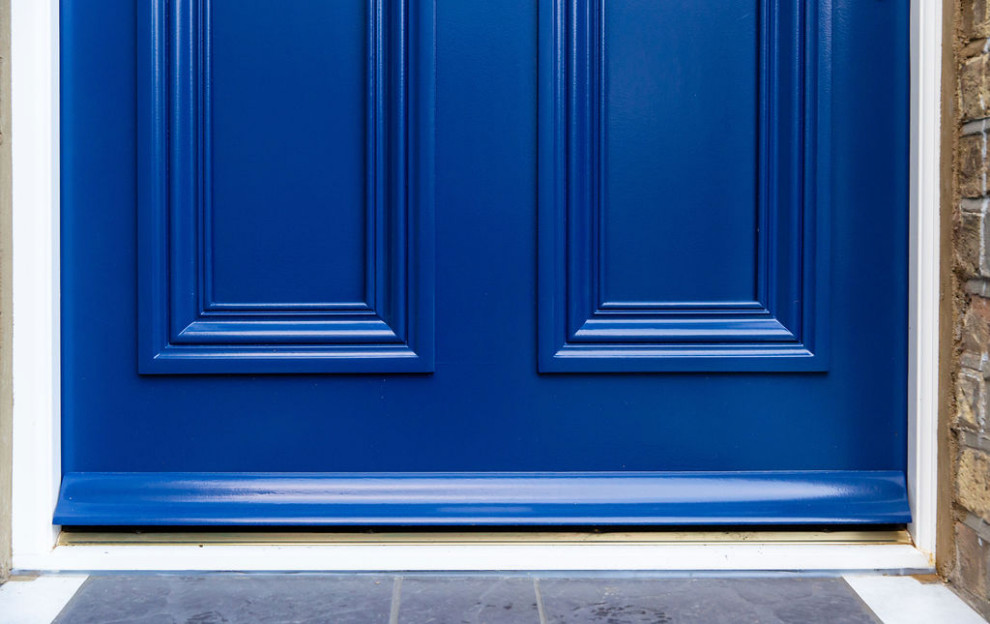 Idée de décoration pour une entrée tradition avec une porte simple et une porte bleue.