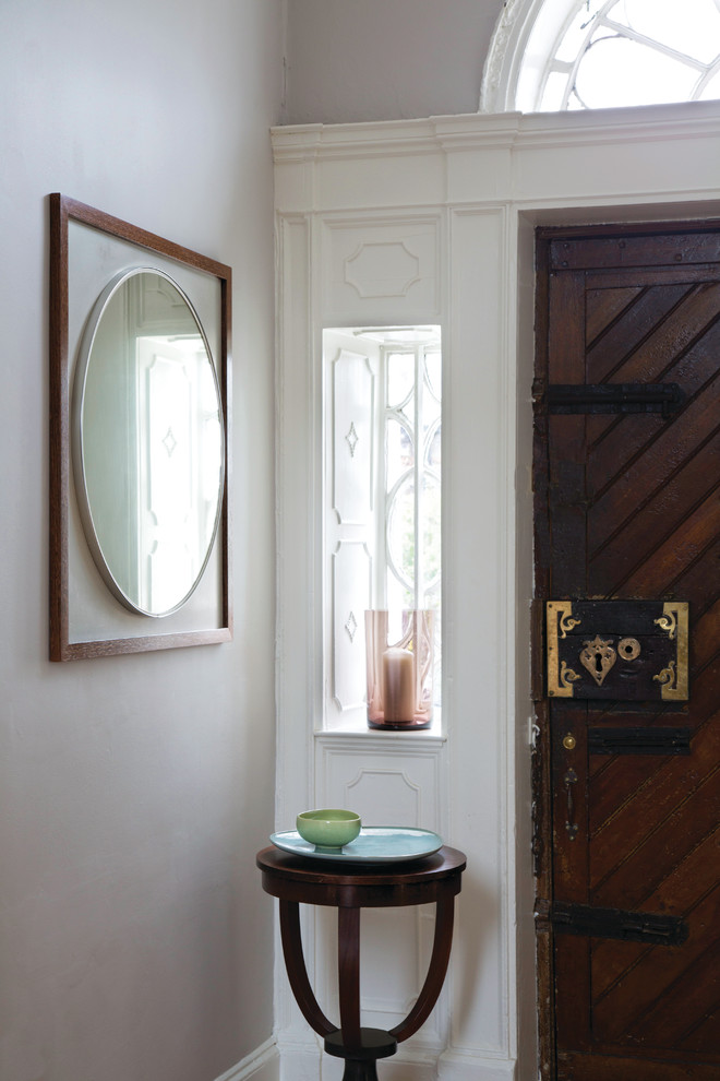 Idée de décoration pour une grande entrée victorienne avec un mur gris, un sol en bois brun, une porte simple et une porte en bois foncé.