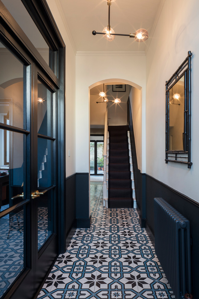 This is an example of a small classic entrance in London with white walls and ceramic flooring.