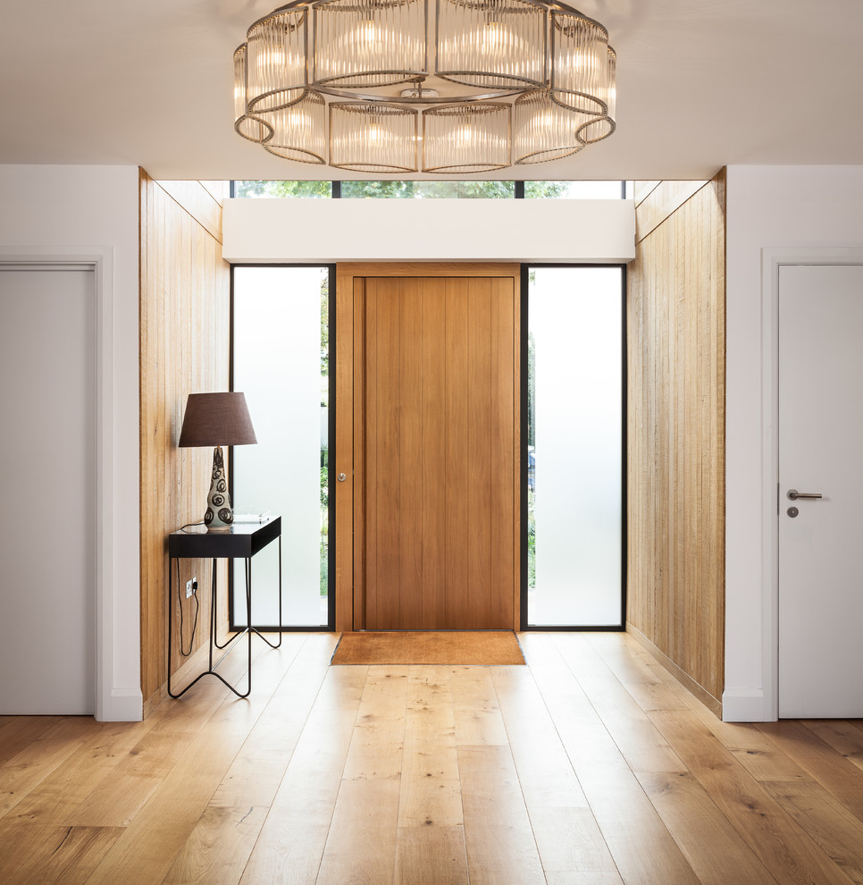 Photo of a medium sized contemporary entrance in Surrey with brown walls, a single front door and brown floors.
