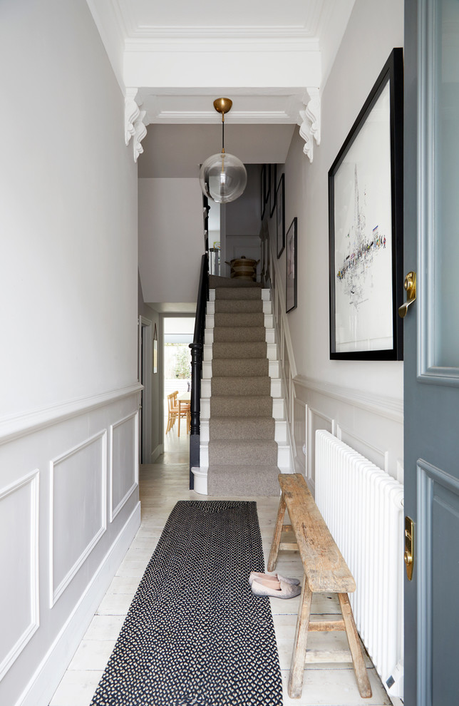 Cette image montre une entrée nordique de taille moyenne avec un couloir, un mur blanc, parquet peint, une porte simple, une porte bleue et un sol beige.
