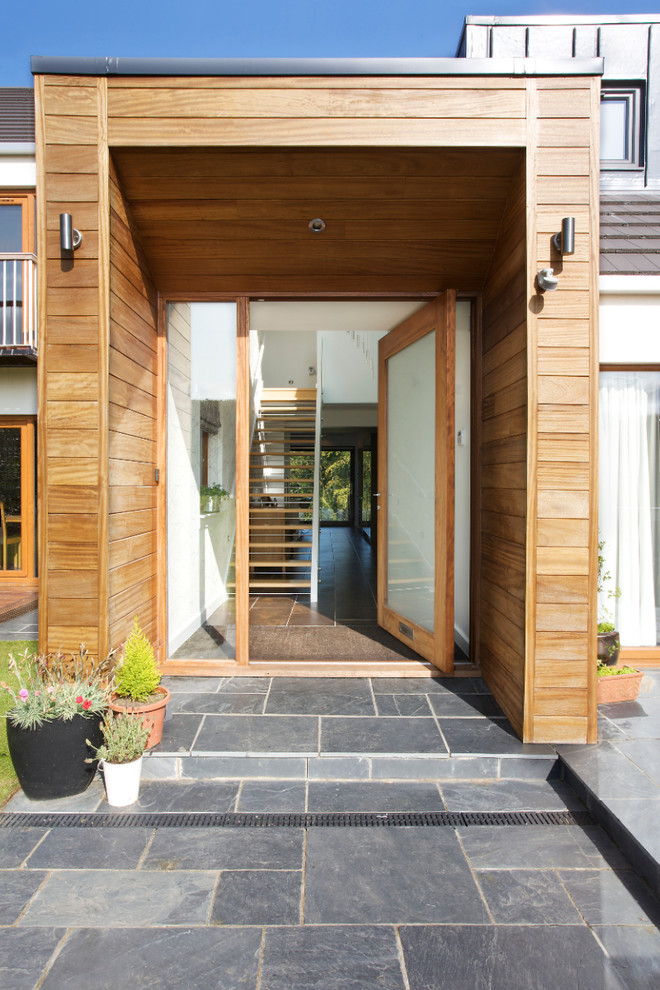 Ispirazione per una porta d'ingresso minimal con pavimento in legno massello medio, una porta singola e una porta in vetro
