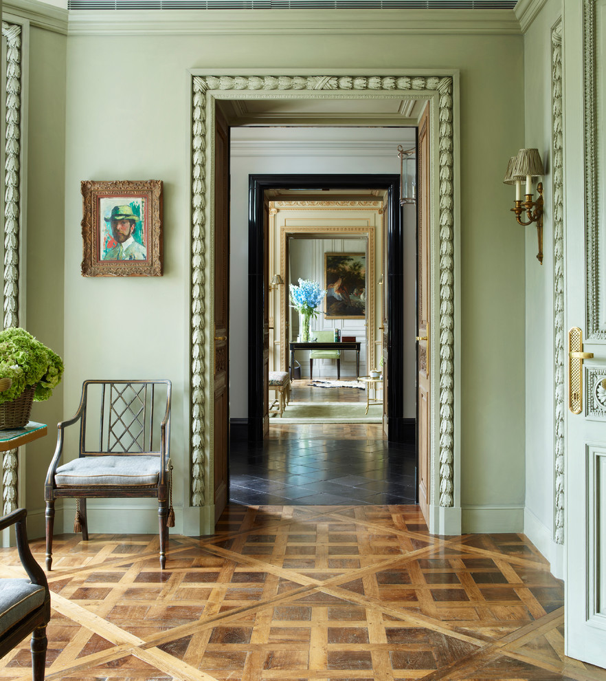 Design ideas for a classic foyer in London with green walls and medium hardwood flooring.
