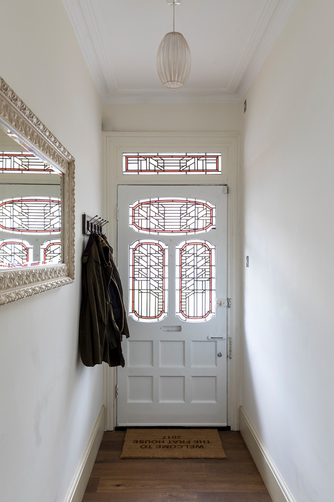 Foto di una piccola porta d'ingresso country con pareti bianche, pavimento in legno massello medio, una porta singola, una porta bianca e pavimento marrone