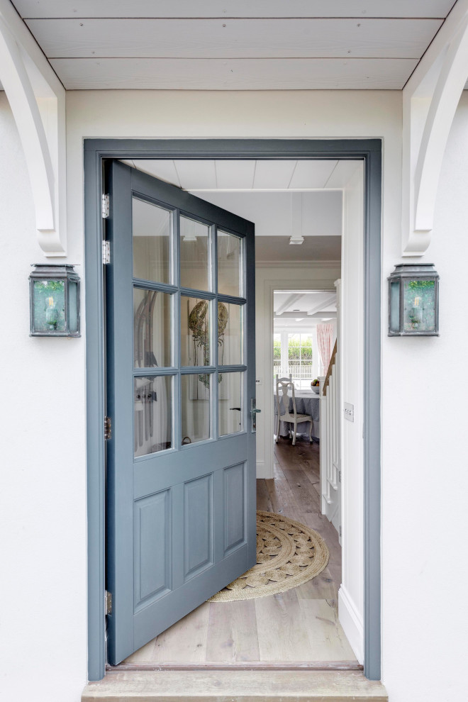 Foto di un grande corridoio stile marinaro con pareti gialle, pavimento in legno massello medio, una porta singola, una porta blu, pavimento marrone, soffitto in perlinato e pannellatura