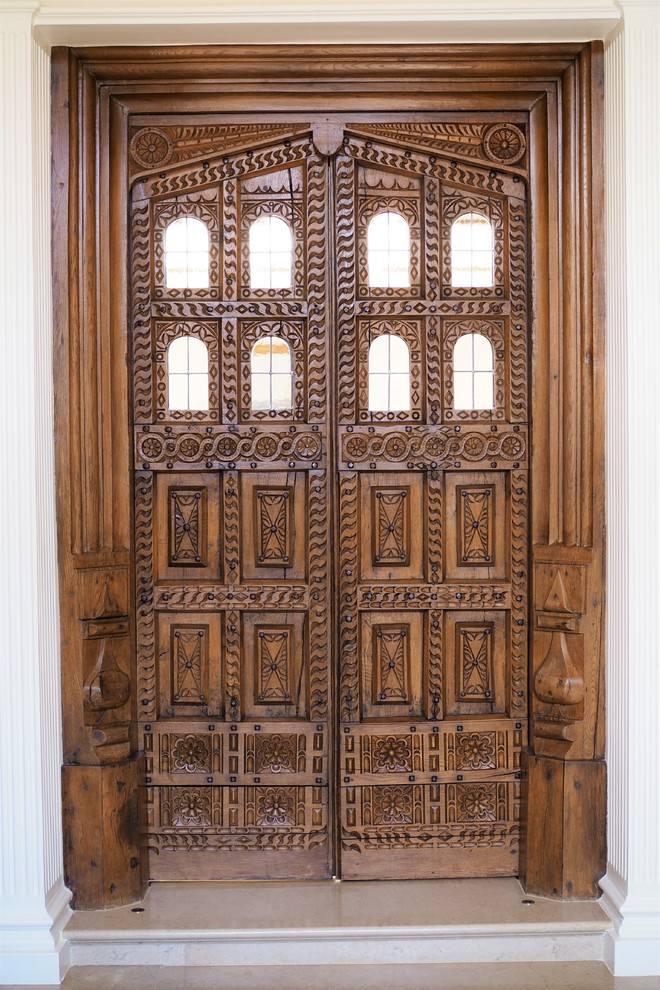 Immagine di un corridoio classico di medie dimensioni con pareti beige, pavimento in granito, una porta a due ante, una porta in legno scuro e pavimento beige
