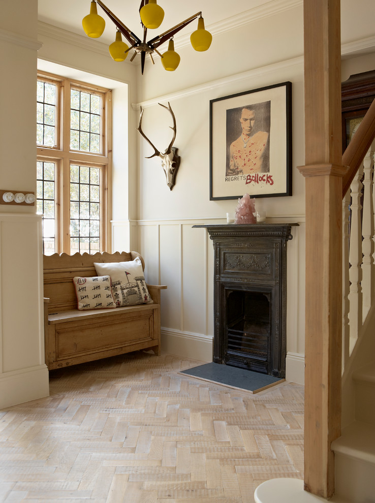 This is an example of a contemporary foyer in London with beige walls and light hardwood flooring.