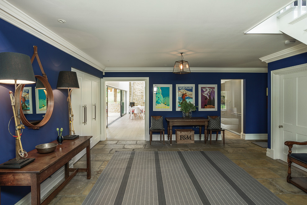 グロスタシャーにあるトランジショナルスタイルのおしゃれな玄関ホール (青い壁、ライムストーンの床、ベージュの床) の写真