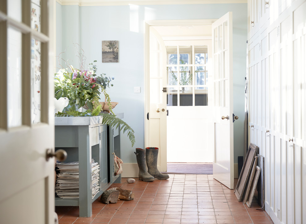 Imagen de entrada tradicional con paredes azules y suelo de baldosas de terracota