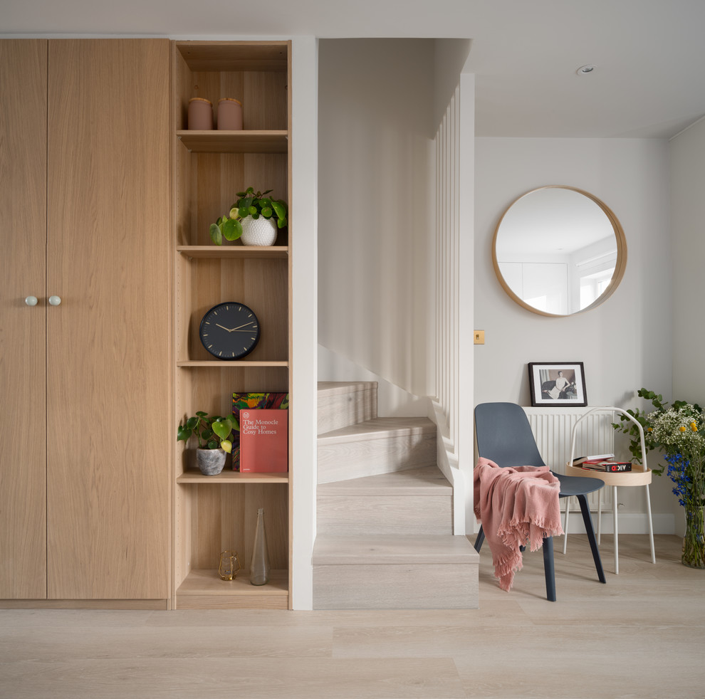 Inspiration för minimalistiska foajéer, med grå väggar, ljust trägolv och beiget golv