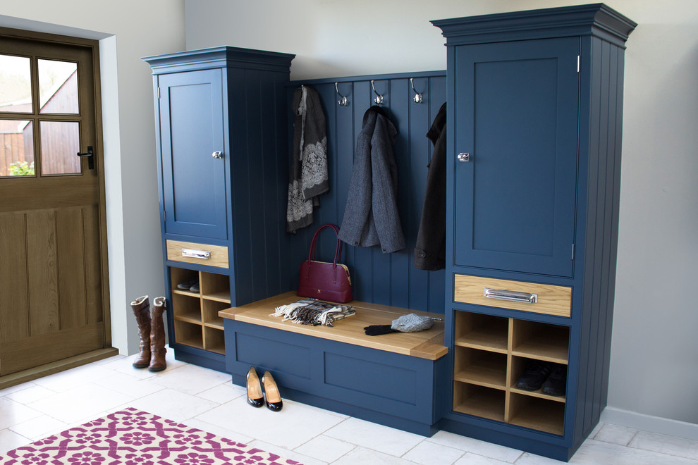 На фото: тамбур среднего размера со шкафом для обуви в классическом стиле с серыми стенами, полом из травертина, одностворчатой входной дверью, синей входной дверью и белым полом с