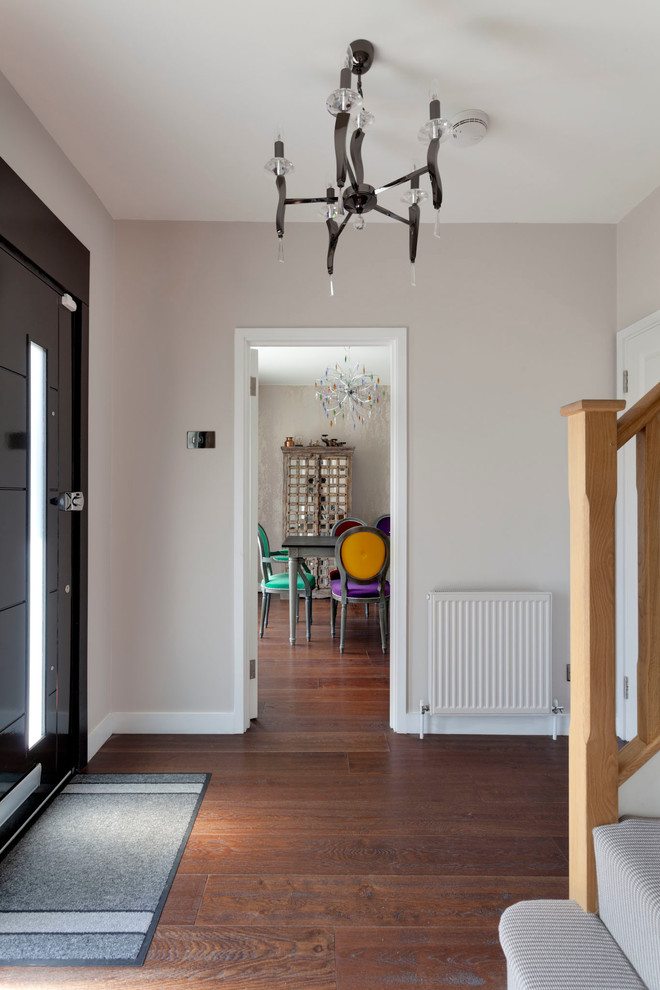 Photo of a contemporary entrance in London with white walls and medium hardwood flooring.