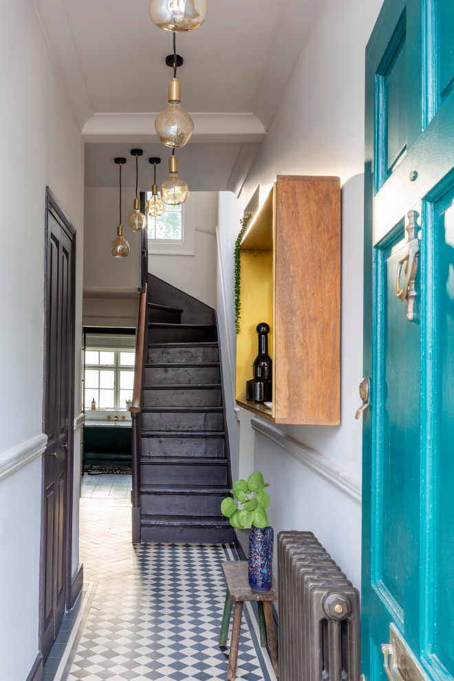Modelo de hall clásico pequeño con paredes blancas, suelo de baldosas de cerámica, puerta simple, puerta azul y suelo multicolor
