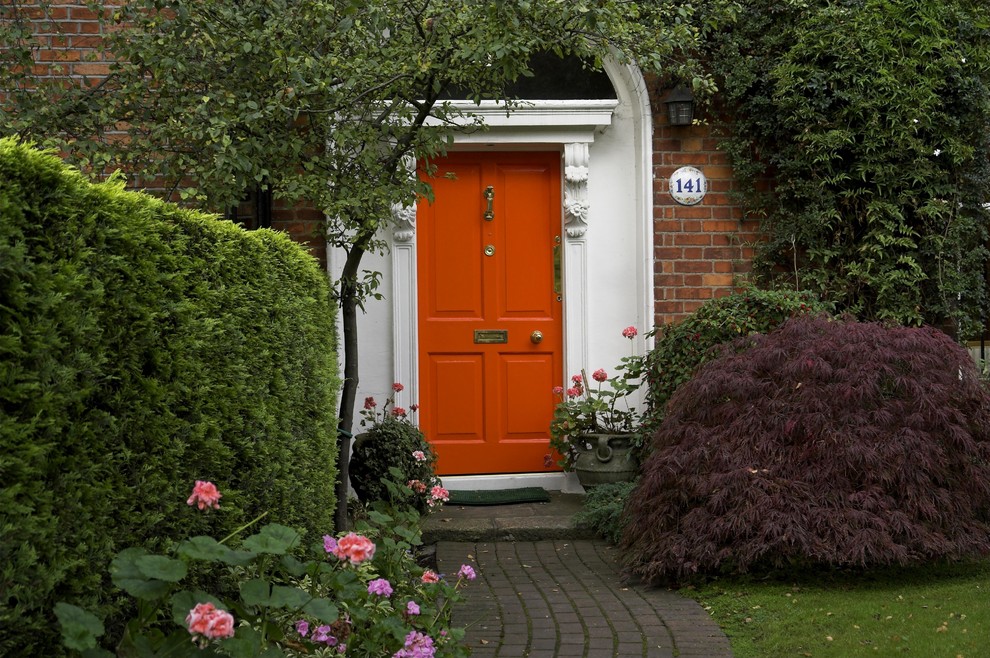 Bild på en mellanstor entré, med en enkeldörr och en röd dörr