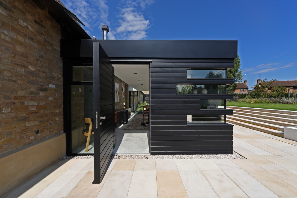 Cette image montre une porte d'entrée design avec une porte pivot et une porte noire.