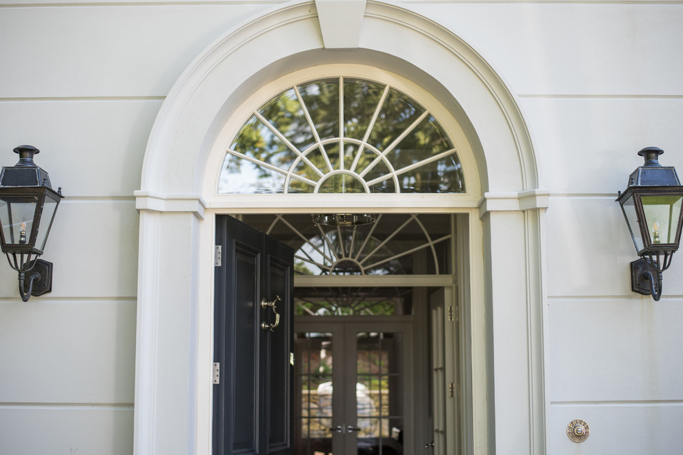 На фото: большая входная дверь в классическом стиле с одностворчатой входной дверью и черной входной дверью с